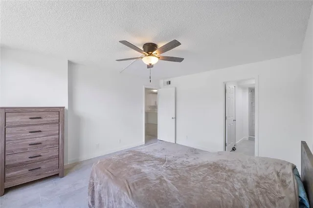 a bedroom with a bed and a ceiling fan