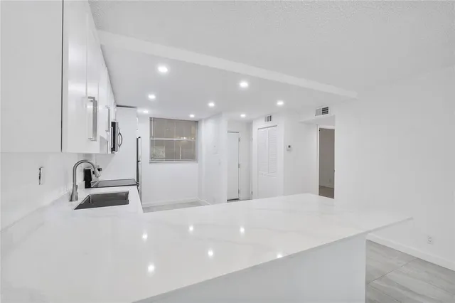 a bathroom with a sink a large mirror and bathtub