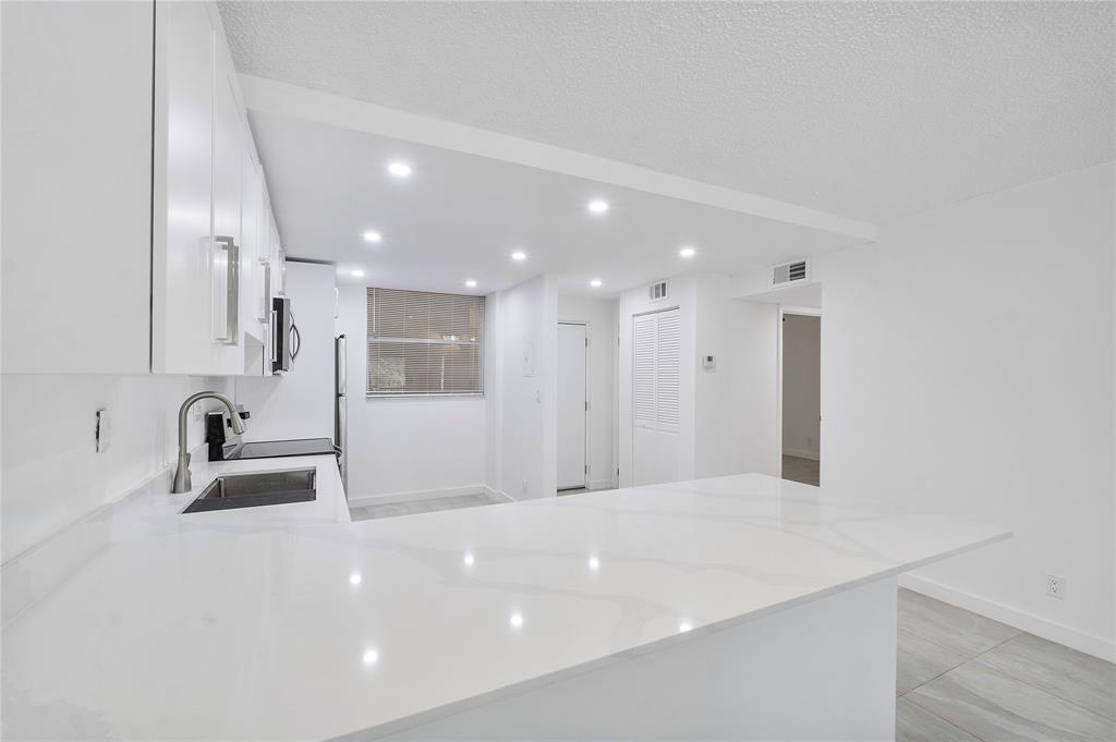 3751 Environ Boulevard, Unit 243 Lauderhill, FL 33319 - Photo 2 of 24 a bathroom with a sink a large mirror and bathtub