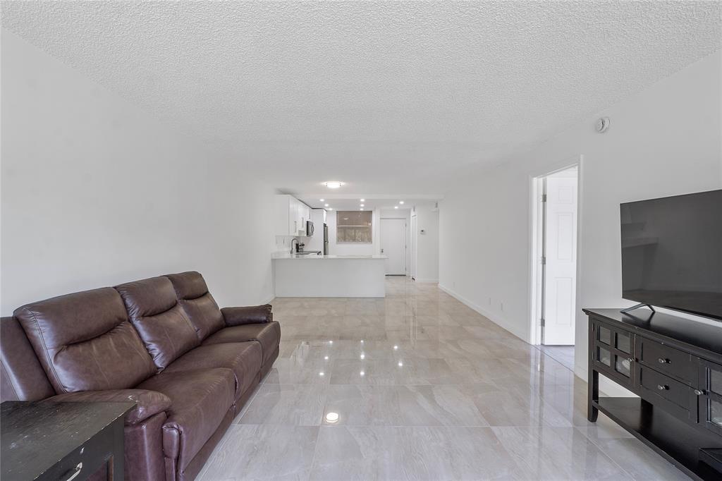 3751 Environ Boulevard, Unit 243 Lauderhill, FL 33319 - Photo 6 of 24 a living room with furniture and a flat screen tv