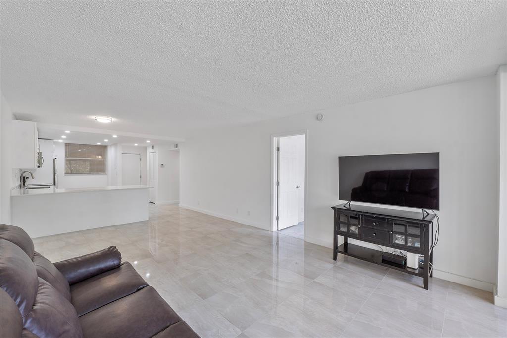 3751 Environ Boulevard, Unit 243 Lauderhill, FL 33319 - Photo 7 of 24 a living room with furniture and a flat screen tv