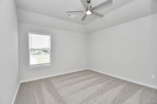 an empty room with a window and a fan