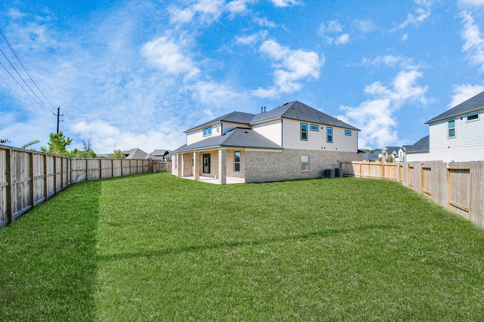 24722 Skerne Woods Drive Spring, TX 77373 - Photo 39 of 39 Explore the expansive backyard with its inviting covered patio—a perfect blend of space for the kids to play and adults to unwind. Ideal for creating your outdoor oasis, this backyard accommodates patio furniture, a BBQ pit, and endless possibilities for leisure and entertainment. Sample photo of completed home with similar floor plan. Actual colors and selections may vary.