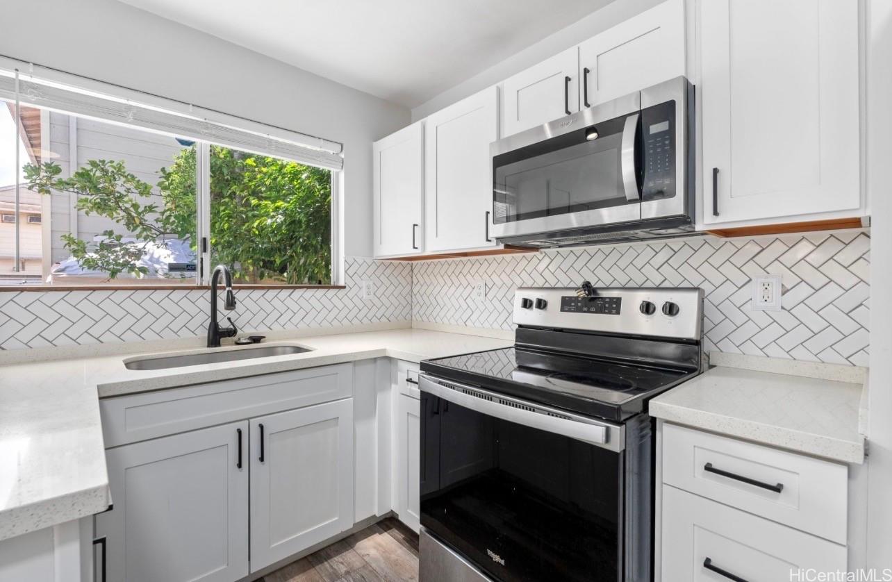 91-241 Makalauna Place, Unit 15 Ewa Beach, HI 96706 - Photo 5 of 15 a kitchen with a sink stove and microwave