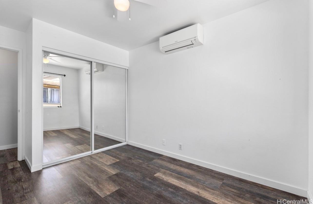 91-241 Makalauna Place, Unit 15 Ewa Beach, HI 96706 - Photo 10 of 15 an empty room with wooden floor cabinet and windows