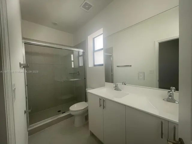 a utility room with a sink a mirror and a toilet