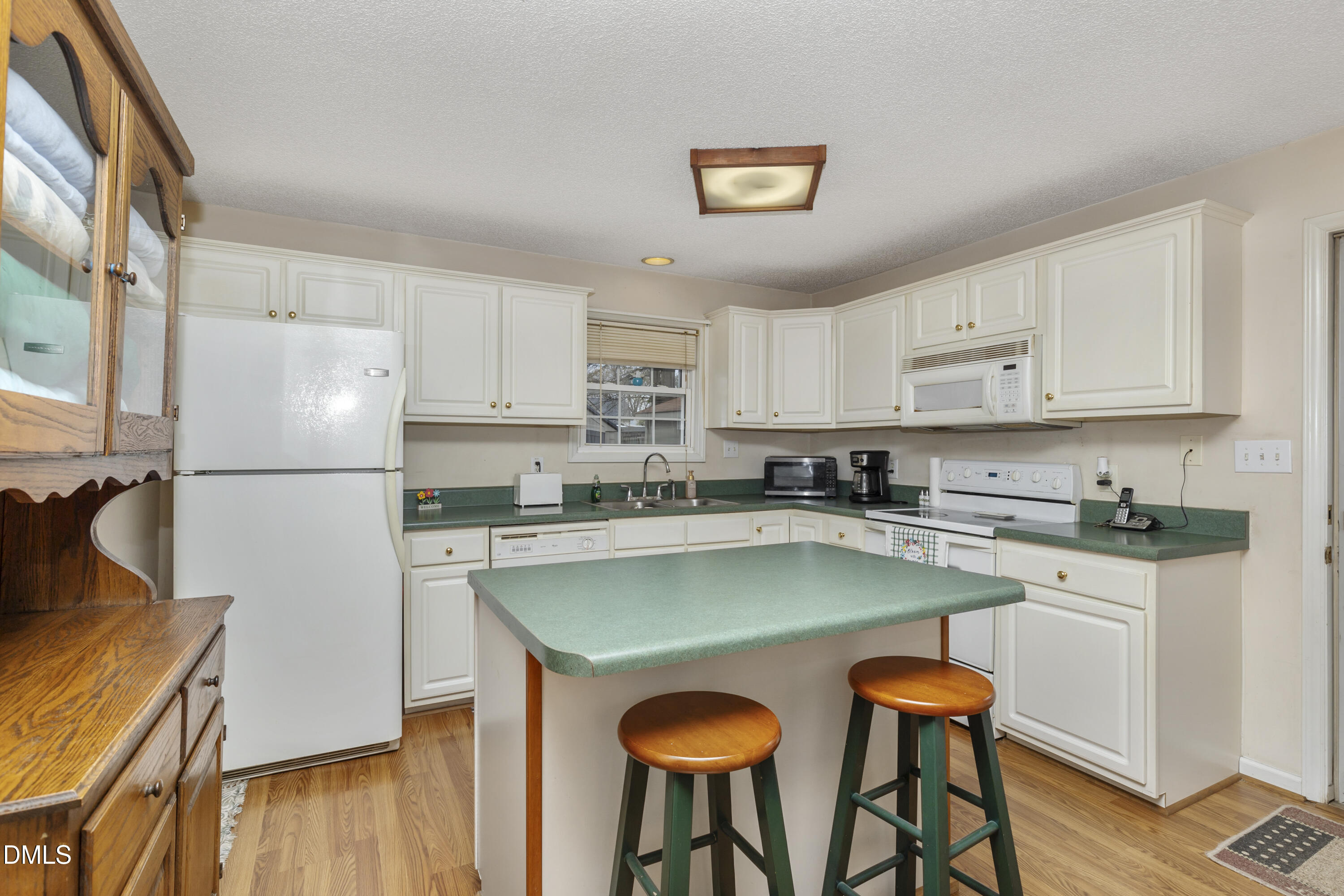 100 East E Street Erwin, NC 28339 - Photo 18 of 27 a kitchen with stainless steel appliances granite countertop a refrigerator a stove a sink dishwasher and white cabinets with wooden floor