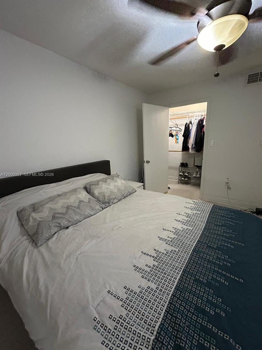 15551 Southwest 104th Terrace, Unit 814 Miami, FL 33196 - Photo 16 of 30 a bed sitting in a bedroom and chandelier