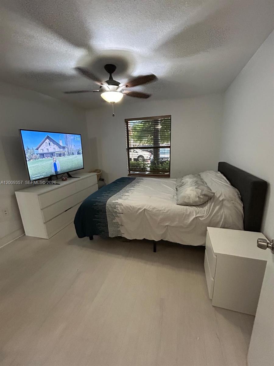 15551 Southwest 104th Terrace, Unit 814 Miami, FL 33196 - Photo 18 of 30 a bedroom with a bed and a chandelier