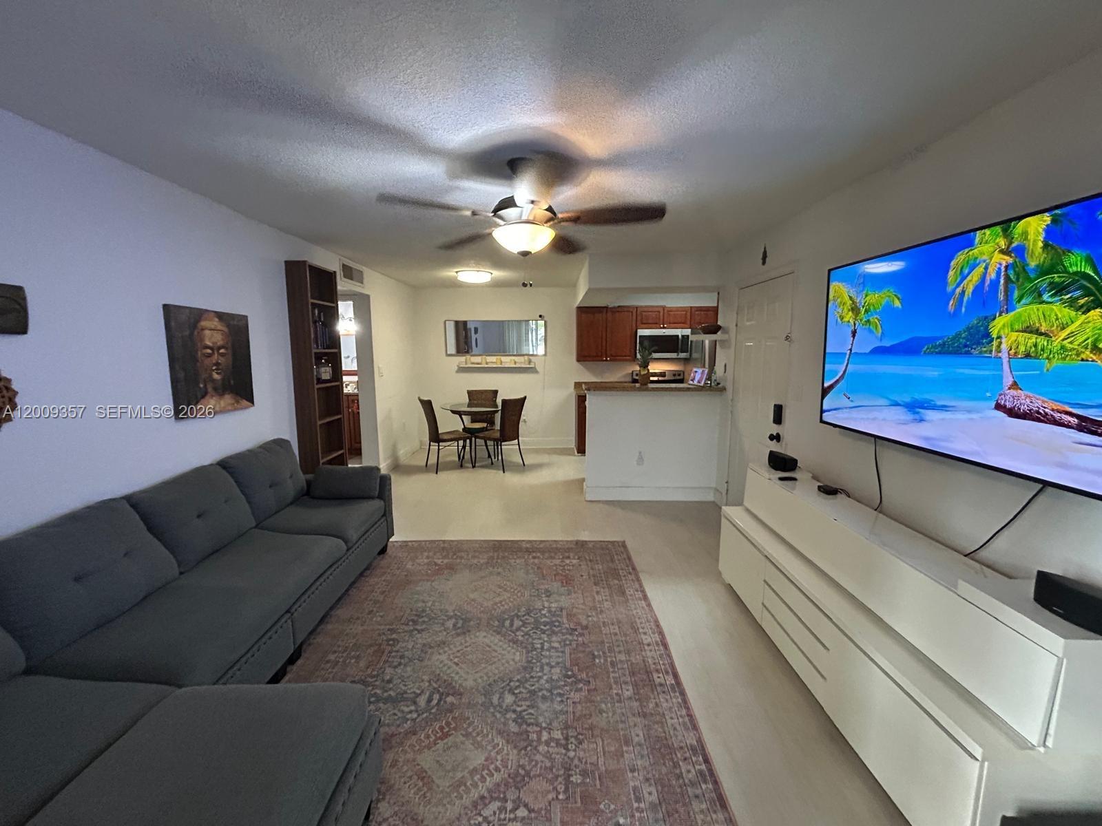 15551 Southwest 104th Terrace, Unit 814 Miami, FL 33196 - Photo 2 of 30 a living room with furniture and a chandelier