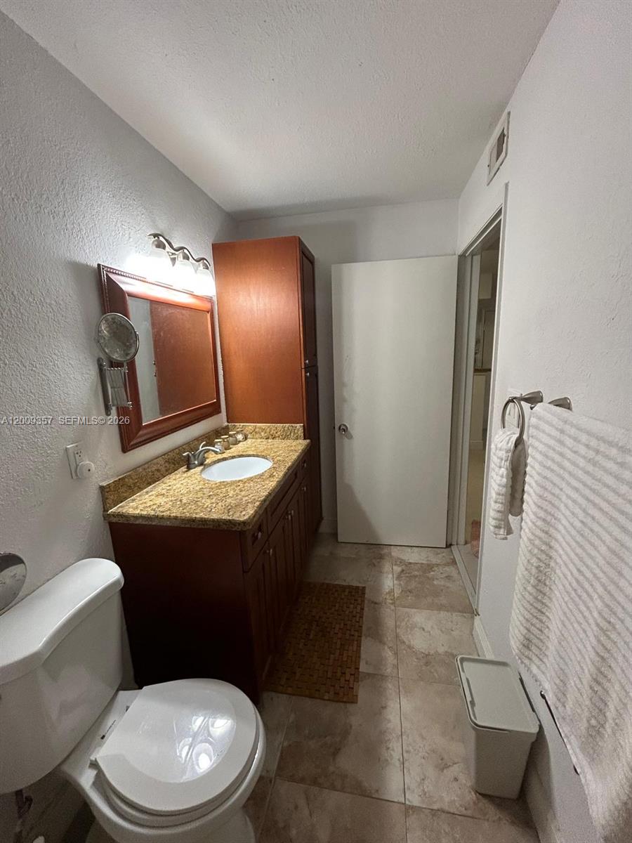15551 Southwest 104th Terrace, Unit 814 Miami, FL 33196 - Photo 21 of 30 a bathroom with a sink a toilet a mirror and vanity