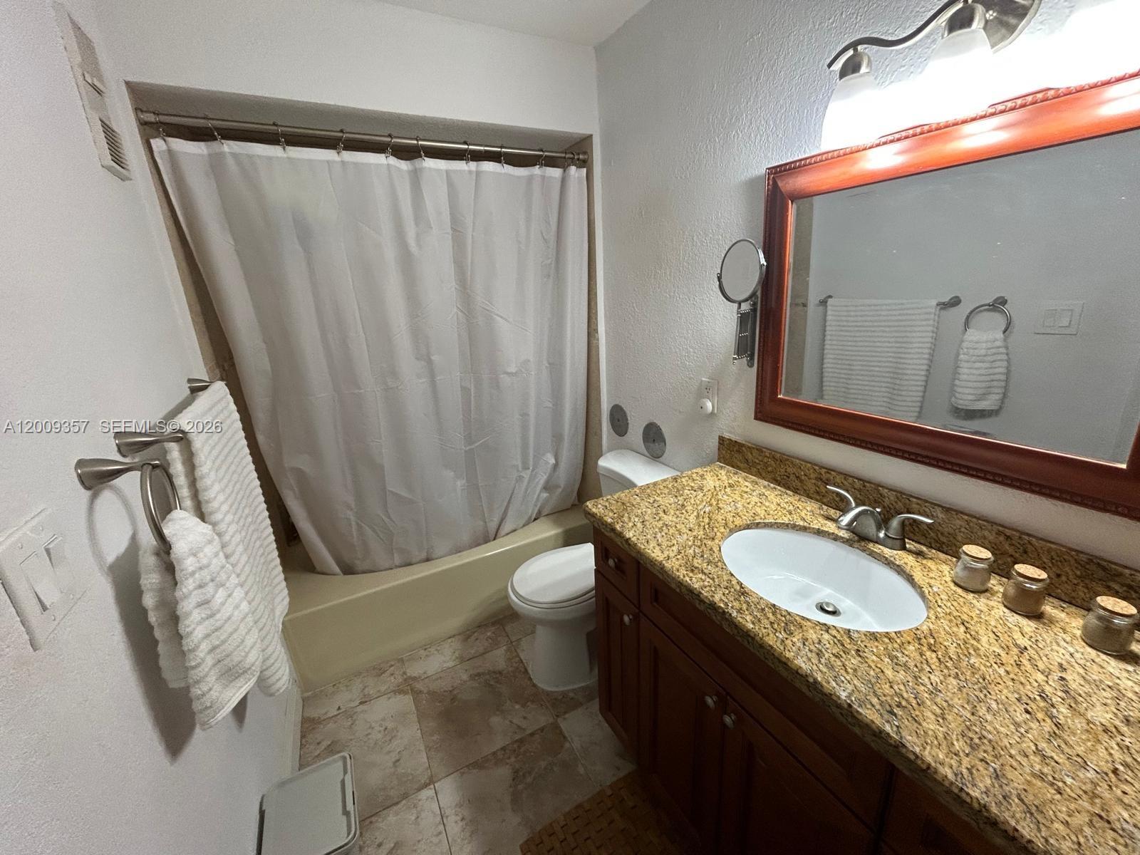 15551 Southwest 104th Terrace, Unit 814 Miami, FL 33196 - Photo 22 of 30 a bathroom with a granite countertop sink and a mirror