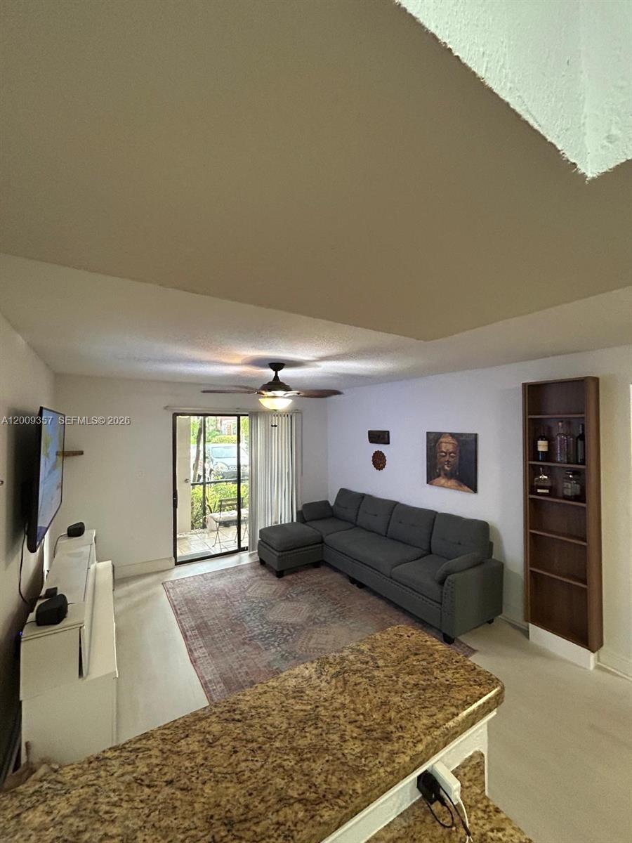 15551 Southwest 104th Terrace, Unit 814 Miami, FL 33196 - Photo 6 of 30 a living room with furniture window and a flat screen tv
