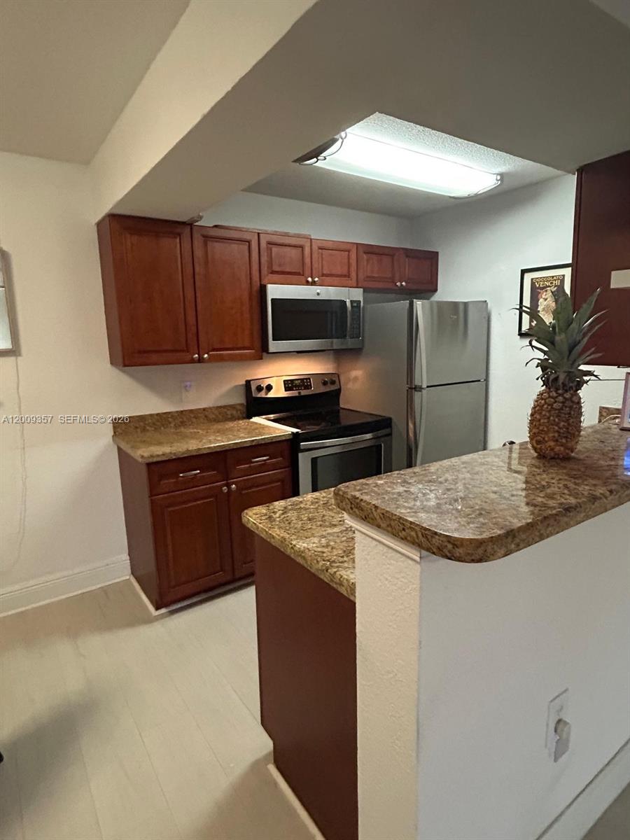 15551 Southwest 104th Terrace, Unit 814 Miami, FL 33196 - Photo 10 of 30 a kitchen with stainless steel appliances granite countertop a sink stove and refrigerator