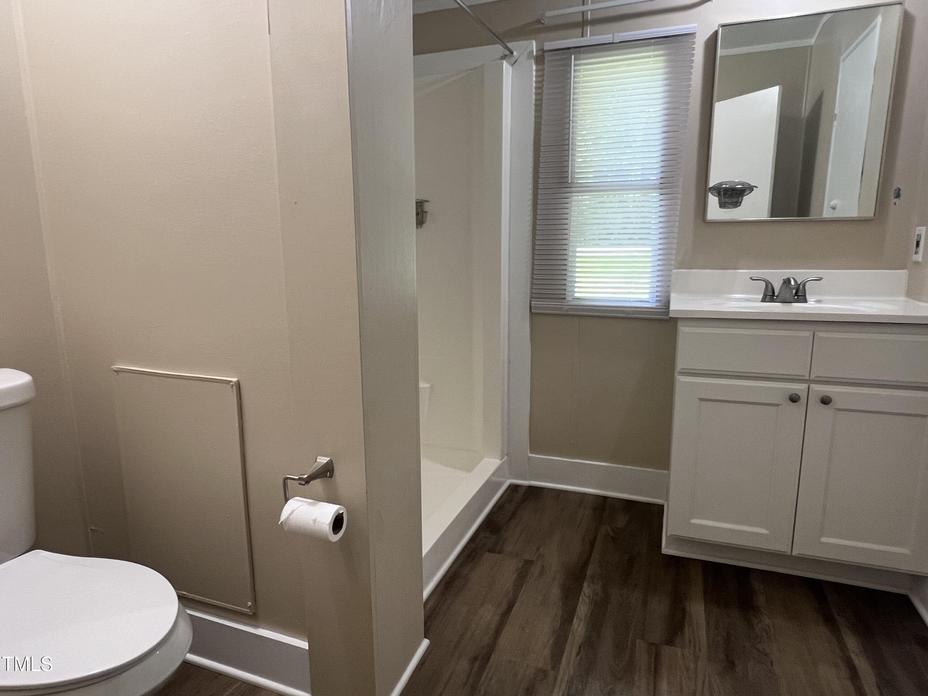 2432 Redwood Road Durham, NC 27704 - Photo 12 of 13 a bathroom with a sink a toilet a window and vanity