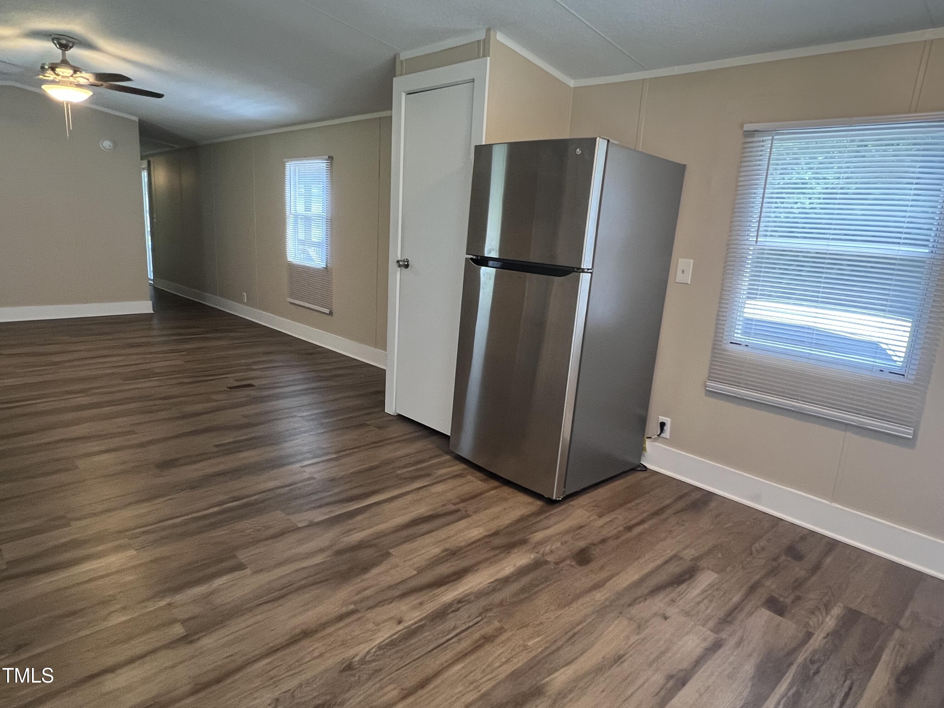2432 Redwood Road Durham, NC 27704 - Photo 9 of 13 a view of a refrigerator in kitchen and an empty room with wooden floor