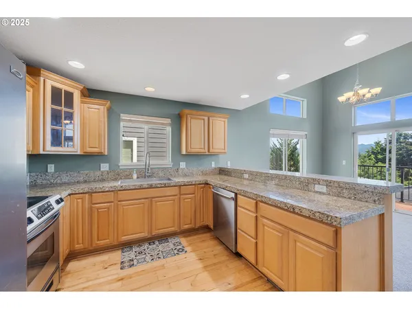 a kitchen with granite countertop sink stove and cabinets