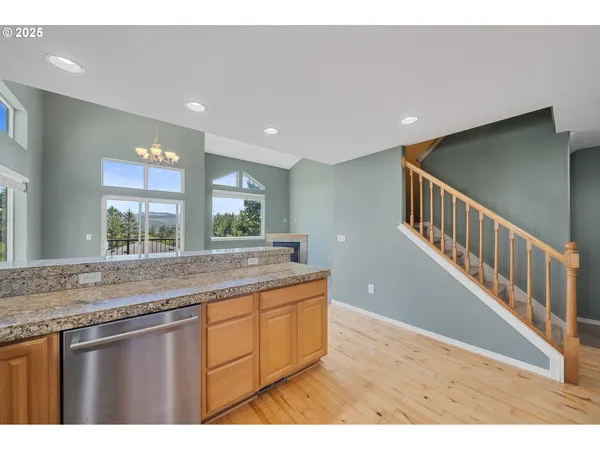 a open kitchen with kitchen island a sink dishwasher a stove and a large island with wooden floor