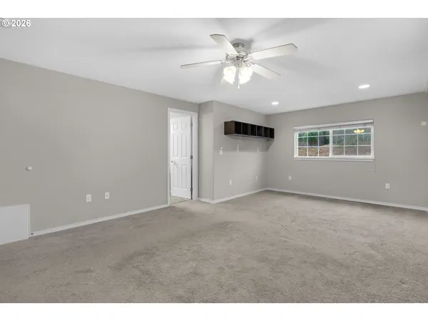 a view of a big room with windows and ceiling fan