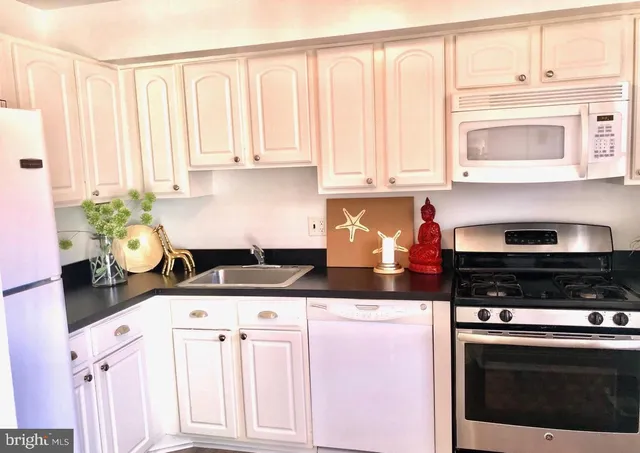 a kitchen with granite countertop a stove a sink and dishwasher