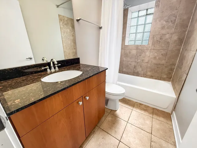 a bathroom with a granite countertop sink a toilet and bathtub