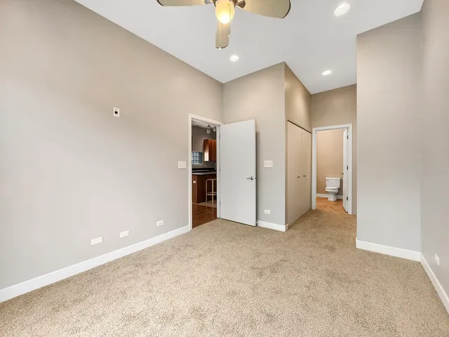 an empty room with a ceiling fan and bathroom