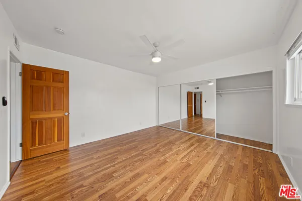a view of an empty room with wooden floor
