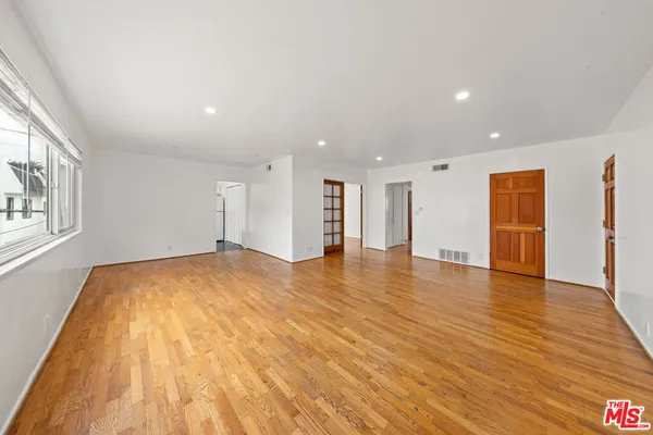 a view of empty room with wooden floor