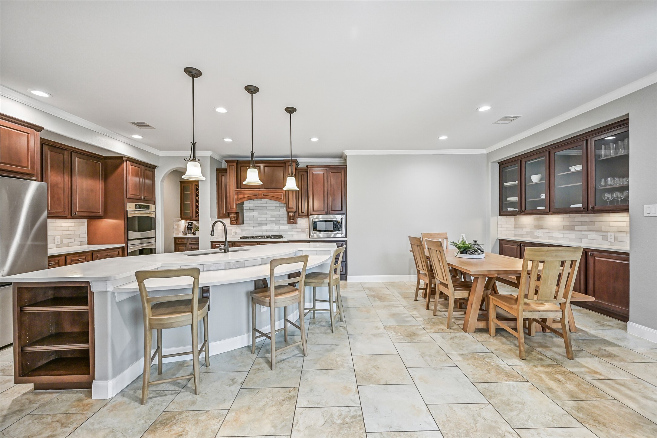 1008 Point Isabel Lane Friendswood, TX 77546 - Photo 18 of 50 This expansive view highlights the open concept design, with the large island anchoring the kitchen while the breakfast area and built-in buffet provide additional seating, storage, and serving space.