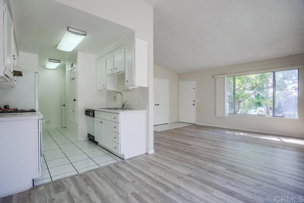 3538 Sandpiper Place Oceanside, CA 92056 - Photo 6 of 16 a view of a kitchen with white cabinets and wooden floor