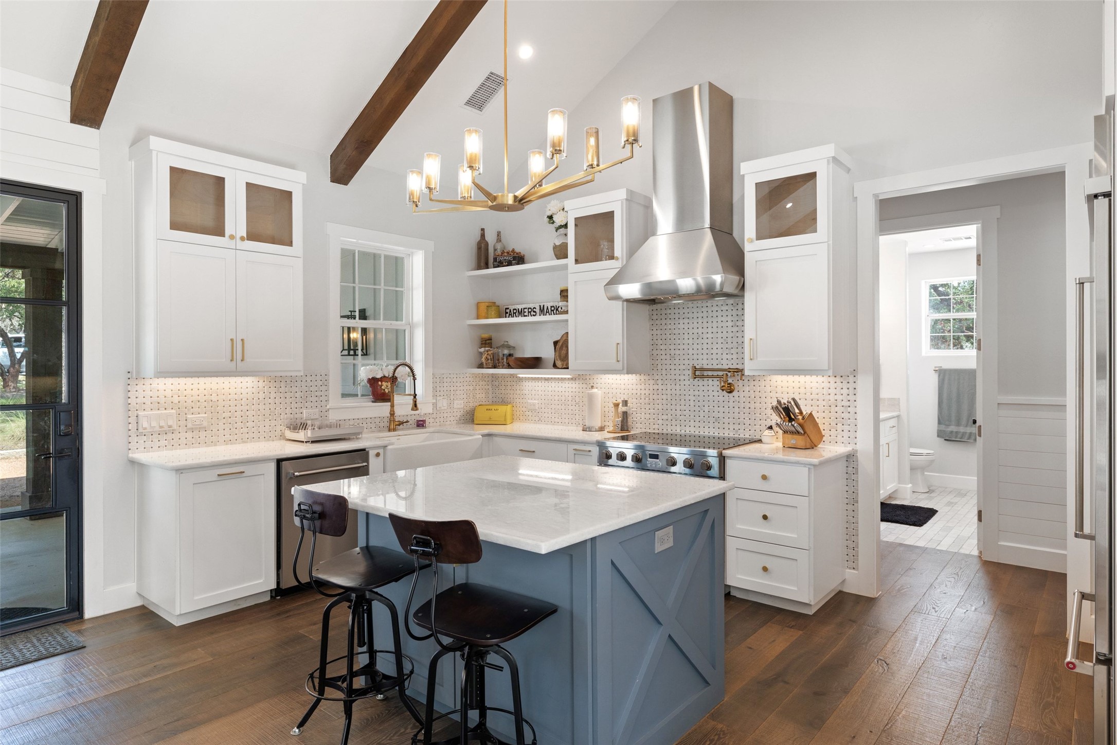 810 Kothmann Road Dripping Springs, TX 78620 - Photo 13 of 40 Vaulted beamed ceilings and rich hardwood flooring frame a beautifully designed kitchen space.