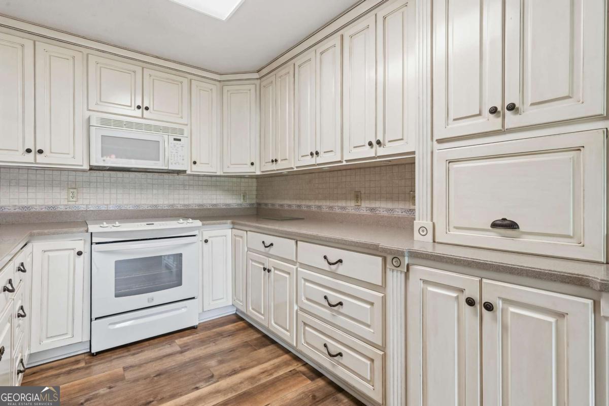56 Claymont Road McIntyre, GA 31054 - Photo 20 of 63 a kitchen with granite countertop white cabinets and a stove