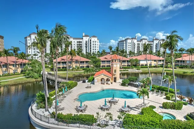 a view of a patio with a table and chairs under an umbrella with a small yard