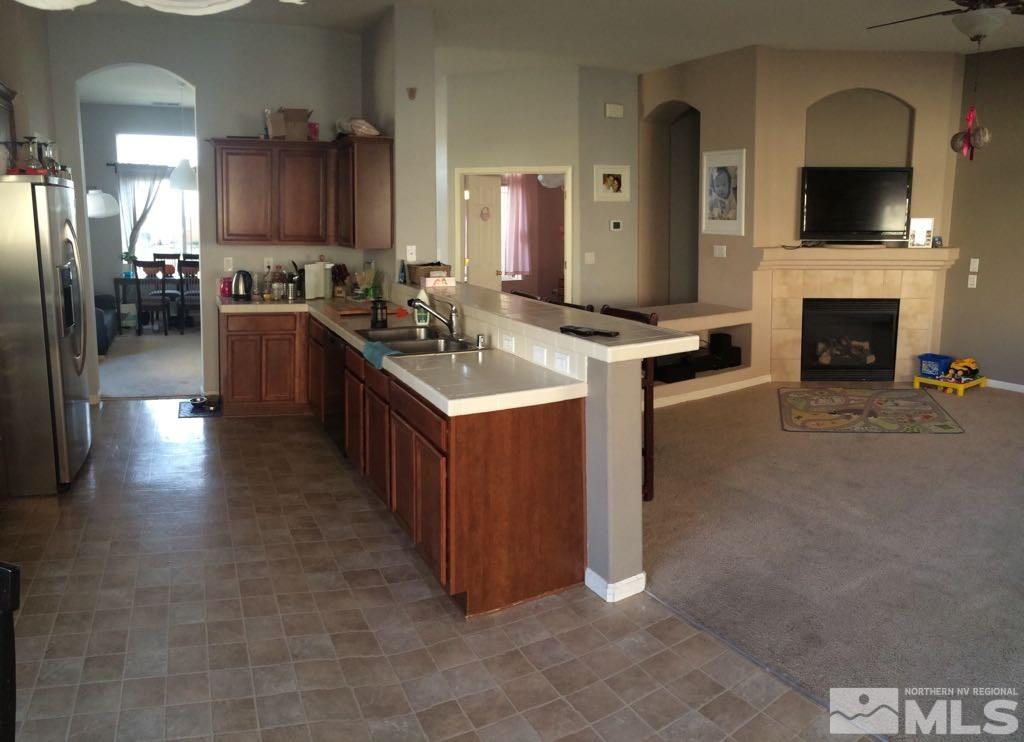 1441 Hagar Road Reno, NV 89506 - Photo 7 of 18 a kitchen with stainless steel appliances granite countertop a refrigerator a stove and a sink with wooden floor