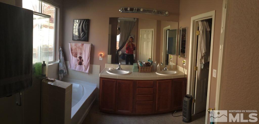 1441 Hagar Road Reno, NV 89506 - Photo 8 of 18 a bathroom with a sink a mirror and a shower