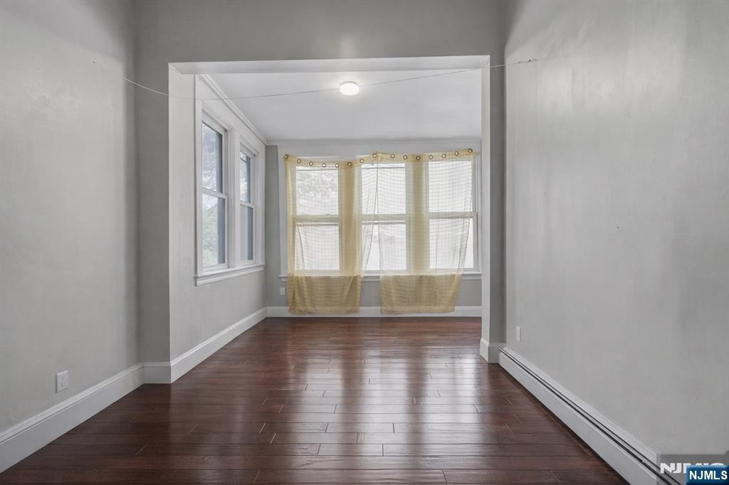 155 Myrtle Avenue Irvington, NJ 07111 - Photo 11 of 26 wooden floor in an empty room with a window