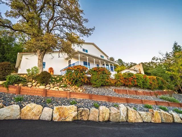 a front view of a house with a yard and mountain view