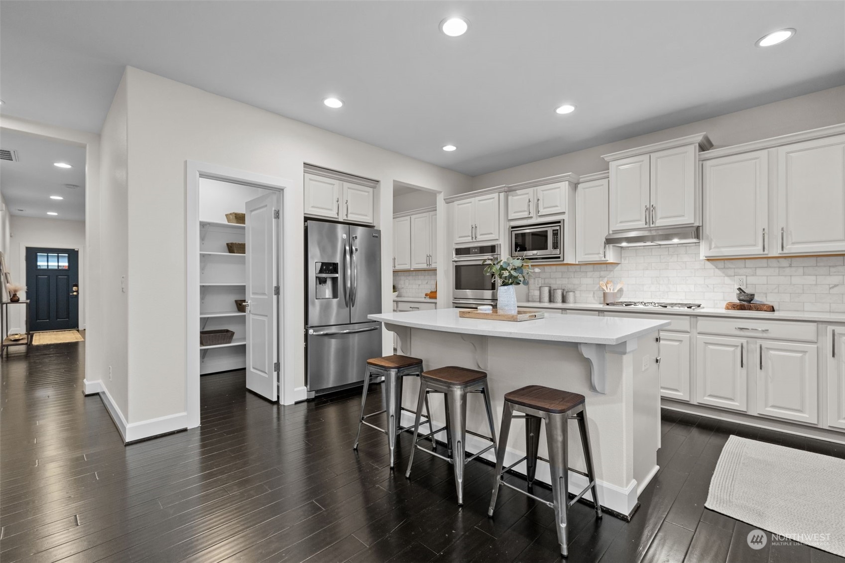 4123 175th Place Southeast Bothell, WA 98012 - Photo 13 of 40 a kitchen with stainless steel appliances granite countertop a refrigerator a stove a sink a dining table and chairs with wooden floor