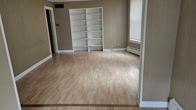 an empty room with wooden floor and closet