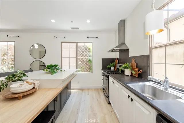 a kitchen with stainless steel appliances a sink a stove and a wooden floors