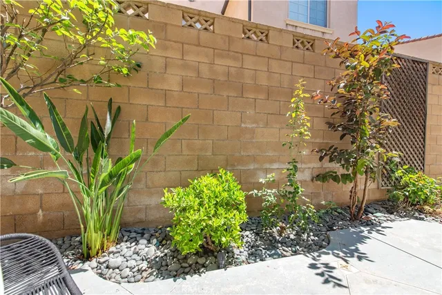 a patio with table and chairs and potted plants
