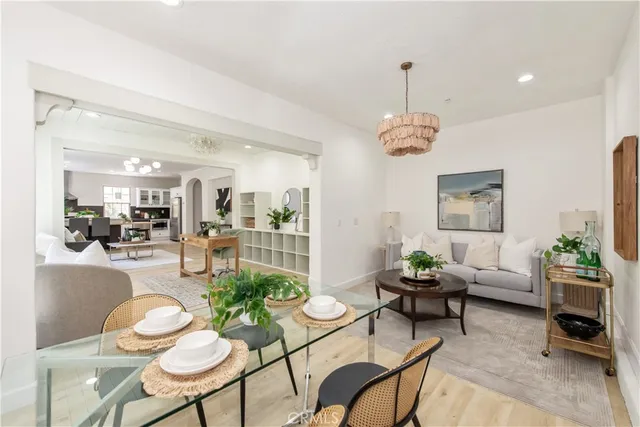 a living room with furniture a chandelier and a dining table
