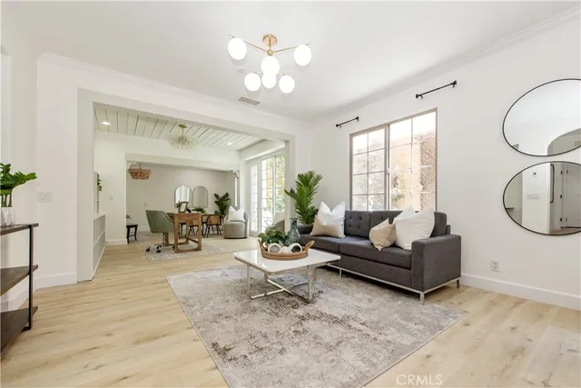a living room with furniture a chandelier and a window