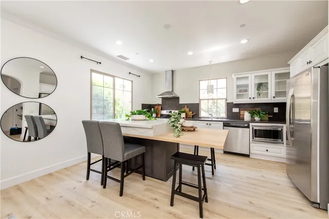 a kitchen with a dining table chairs and white appliances