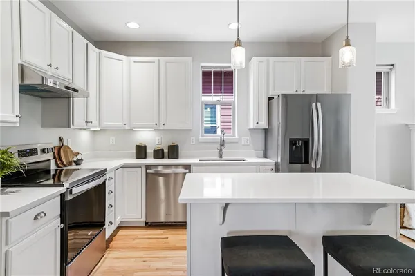 a kitchen with a sink a refrigerator and a stove