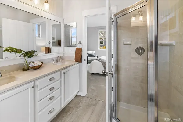 a spacious bathroom with a granite countertop sink mirror and shower