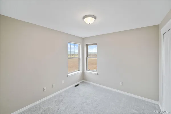 an empty room with windows and closet