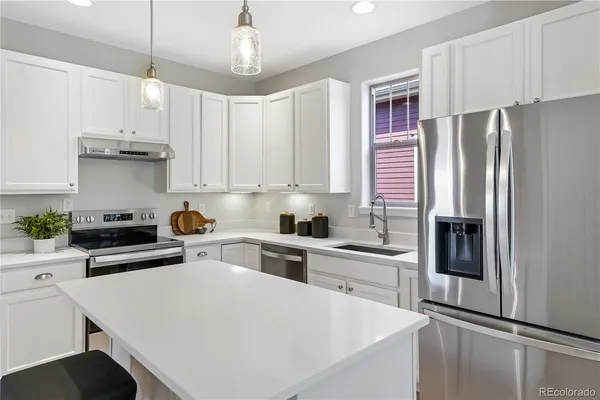 a kitchen with stainless steel appliances a refrigerator sink and white cabinets