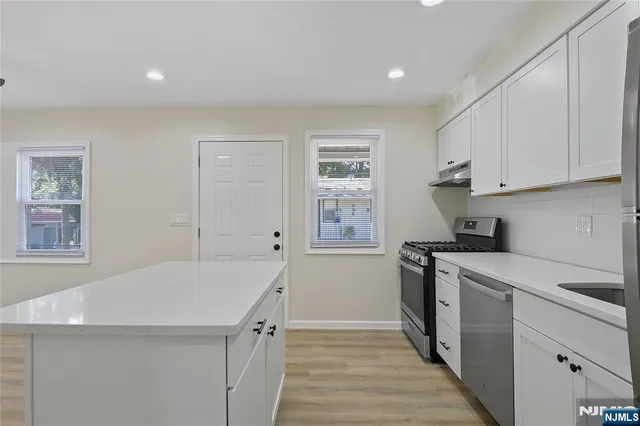 a kitchen with a sink a stove and cabinets