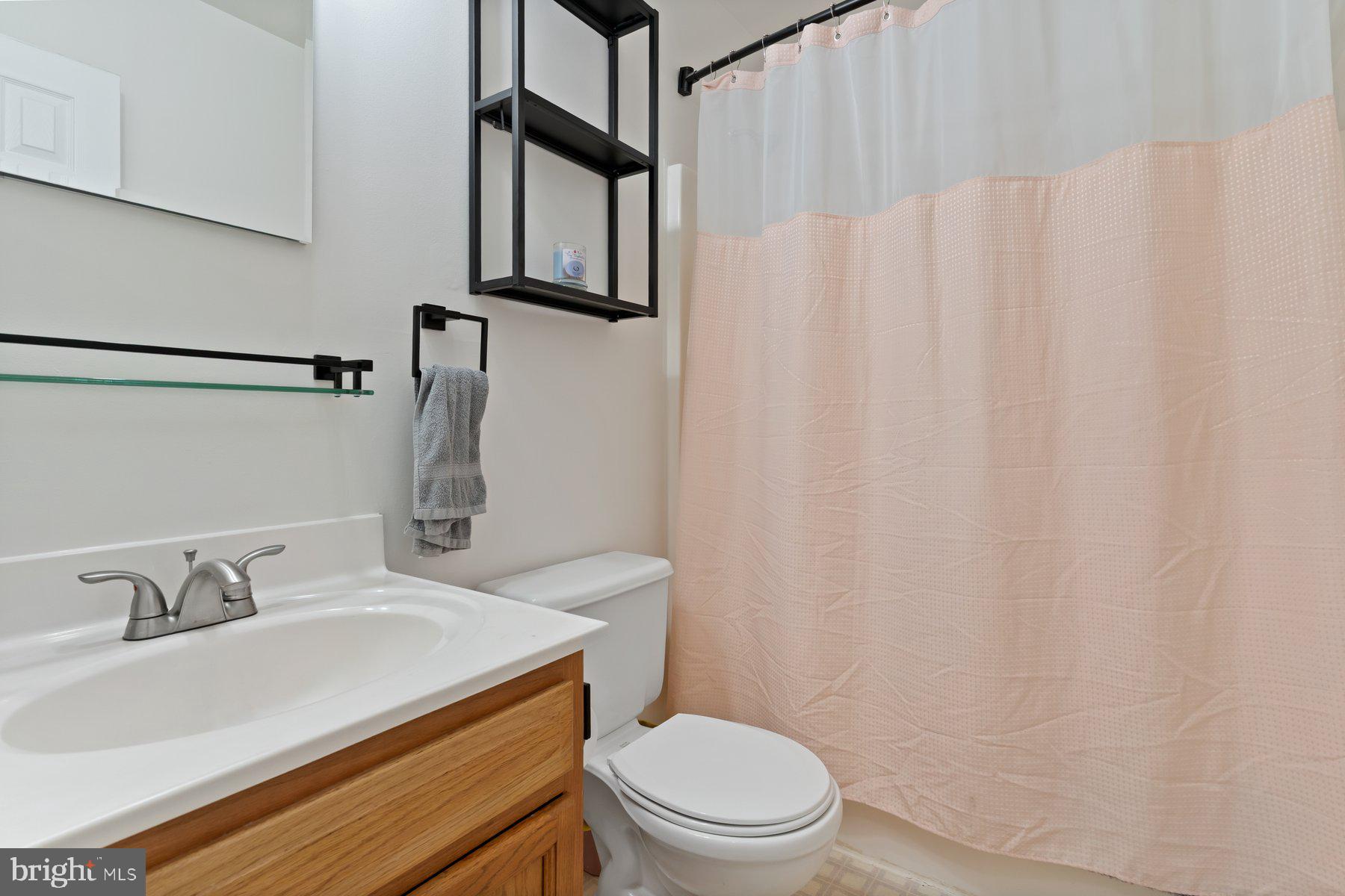 6571 11th Street Chesapeake Beach, MD 20732 - Photo 17 of 36 a bathroom with a sink toilet and mirror